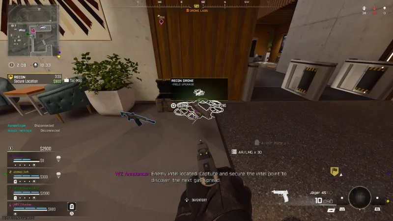 Recon Drone field upgrade sitting in an open crate in the wood panelled Drone Labs lobby, with the equip prompt showing and a Warzone announcer line about capturing the intel point across the screen.